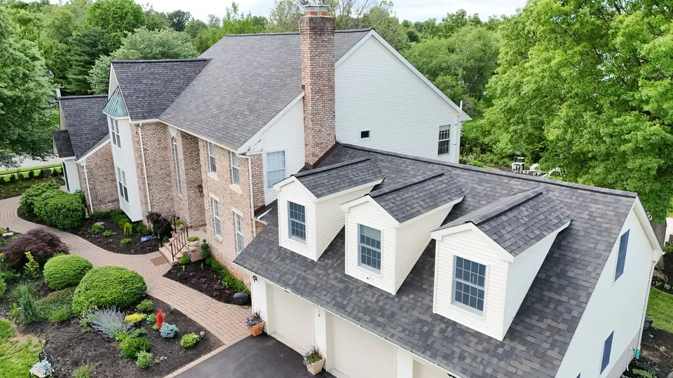 New gray shingle roof with dormers and a brick chimney on a Central New Jersey home