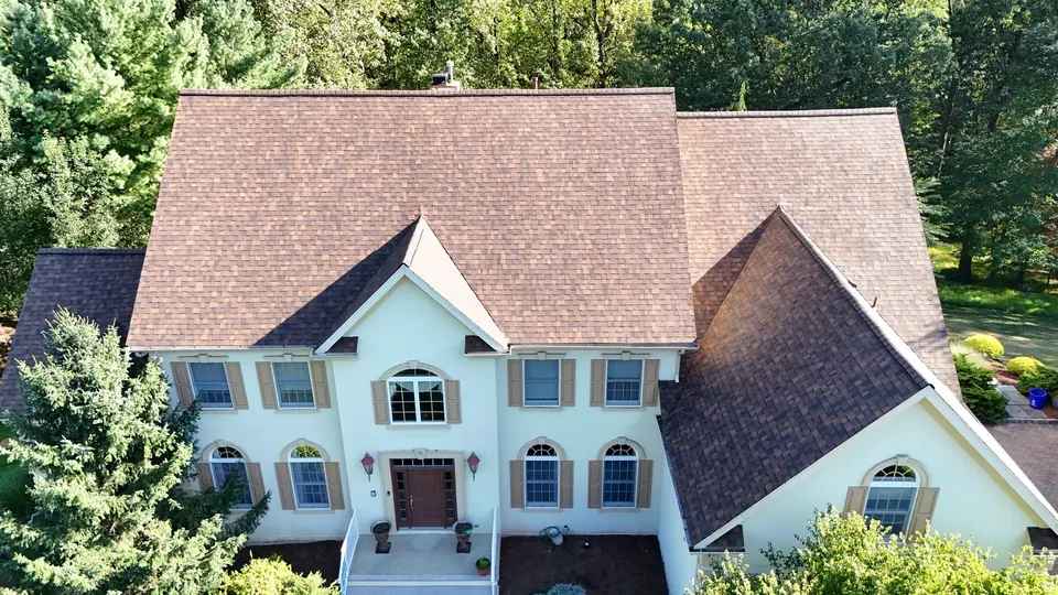 Light toned shingle roof on a pale blue two story home, front aerial view