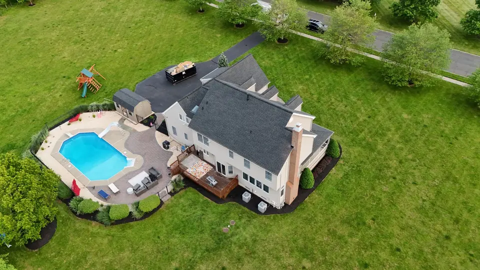 Overhead view of a new roof on a family home with a pool and back yard