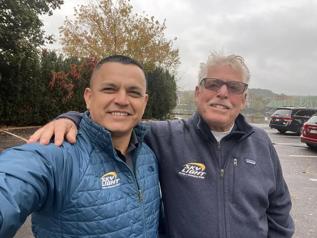 Two members of the Skylight Roofing team after a job